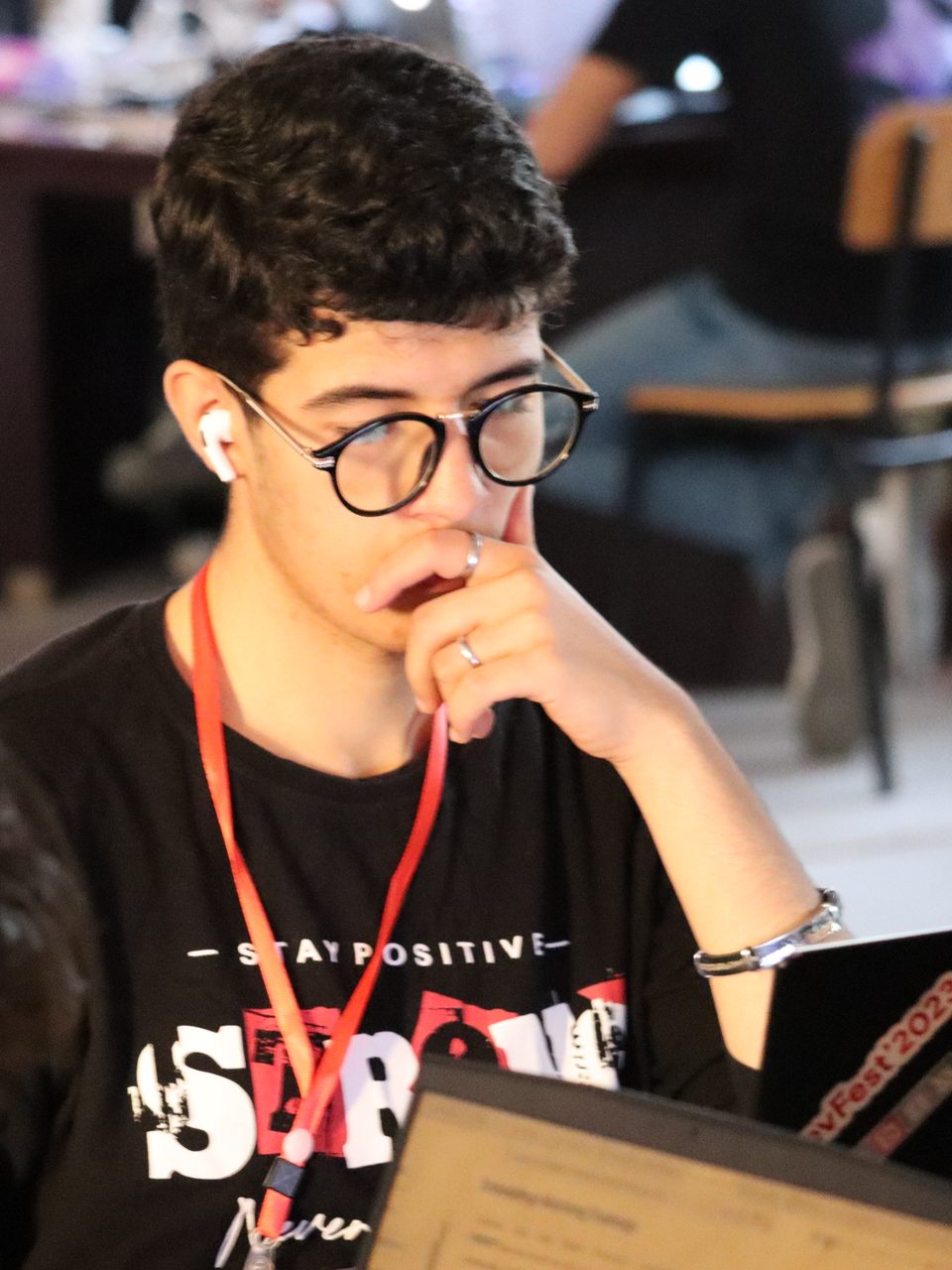 Mouadh Assal at a hackathon, thinking over a laptop
